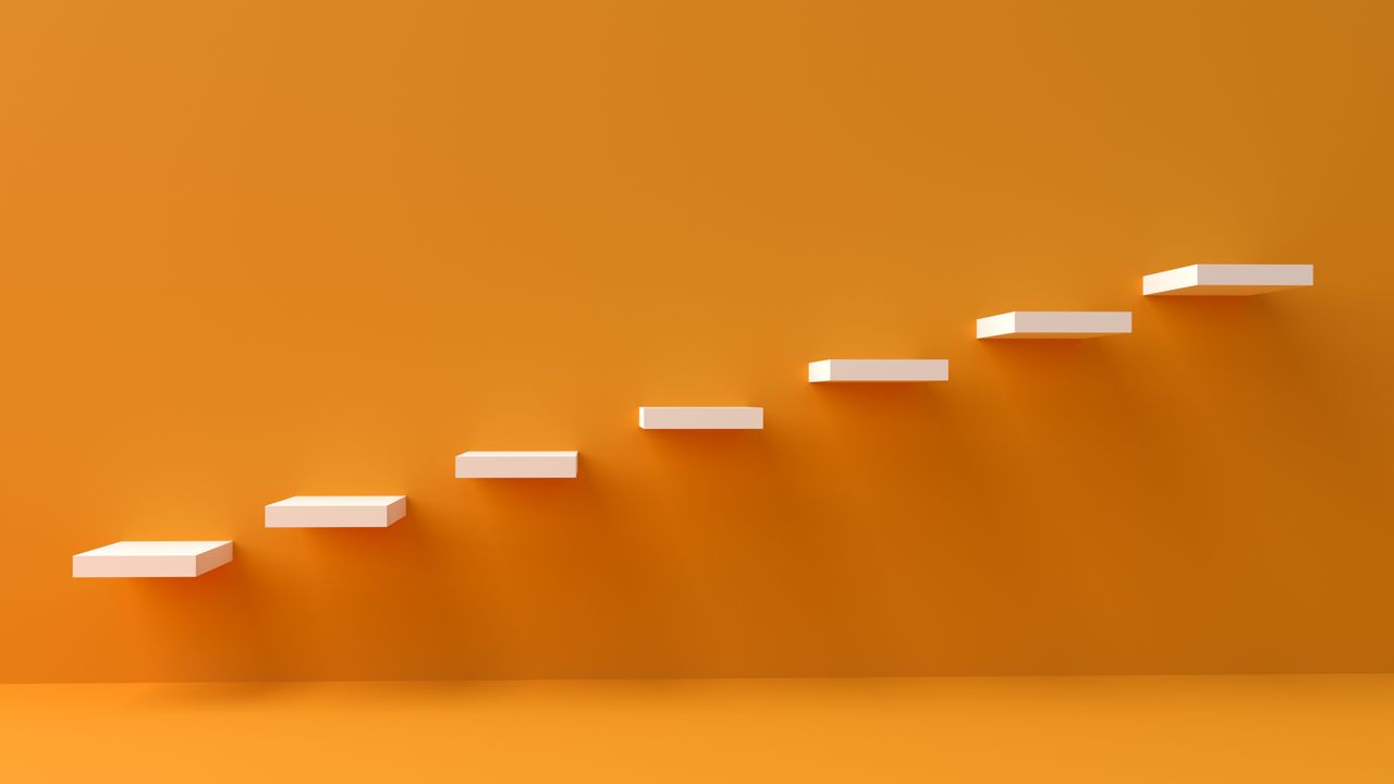 White floating steps on vibrant orange wall create a minimalist and conceptual design.